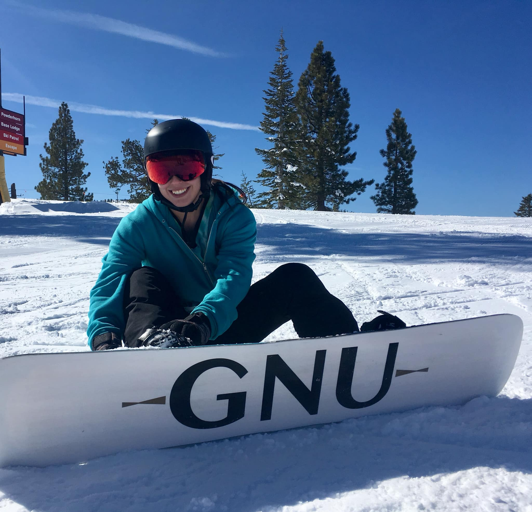 Me sitting on snow strapping my snowboard bindings in